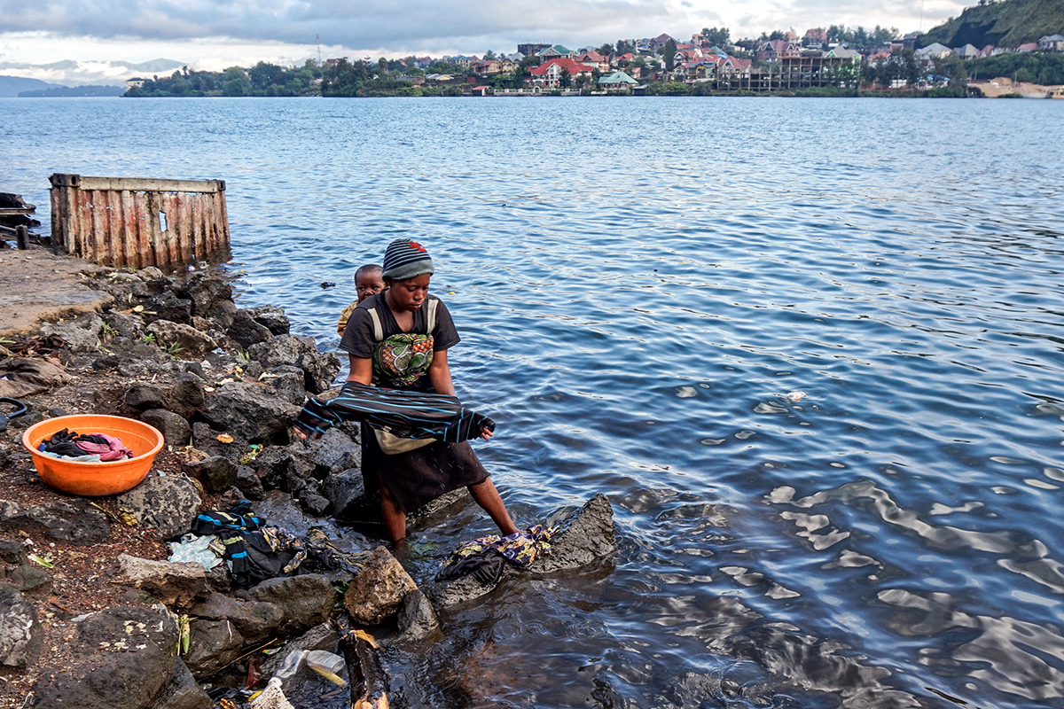 Catherine Mutokambali, of Himbi, a neighborhood in Goma, Democratic Republic of Congo, washes her clothes on the shore of Lake Kivu. According to Mutokambali, XX water shortages at her home have caused her to wake up at 5 a.m. every morning to wash her laundry. (Nadia Kanyere Karasisi, GPJ Democratic Republic of Congo)